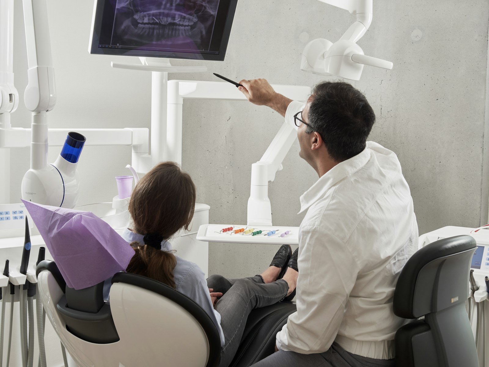 A dentist talking a patient through her X-ray on screen
